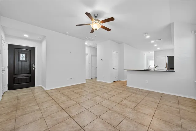 a view of an empty room and kitchen view