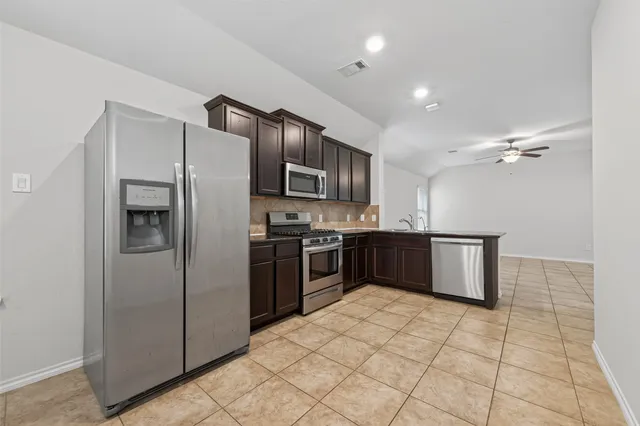 a kitchen with stainless steel appliances granite countertop a refrigerator and a stove