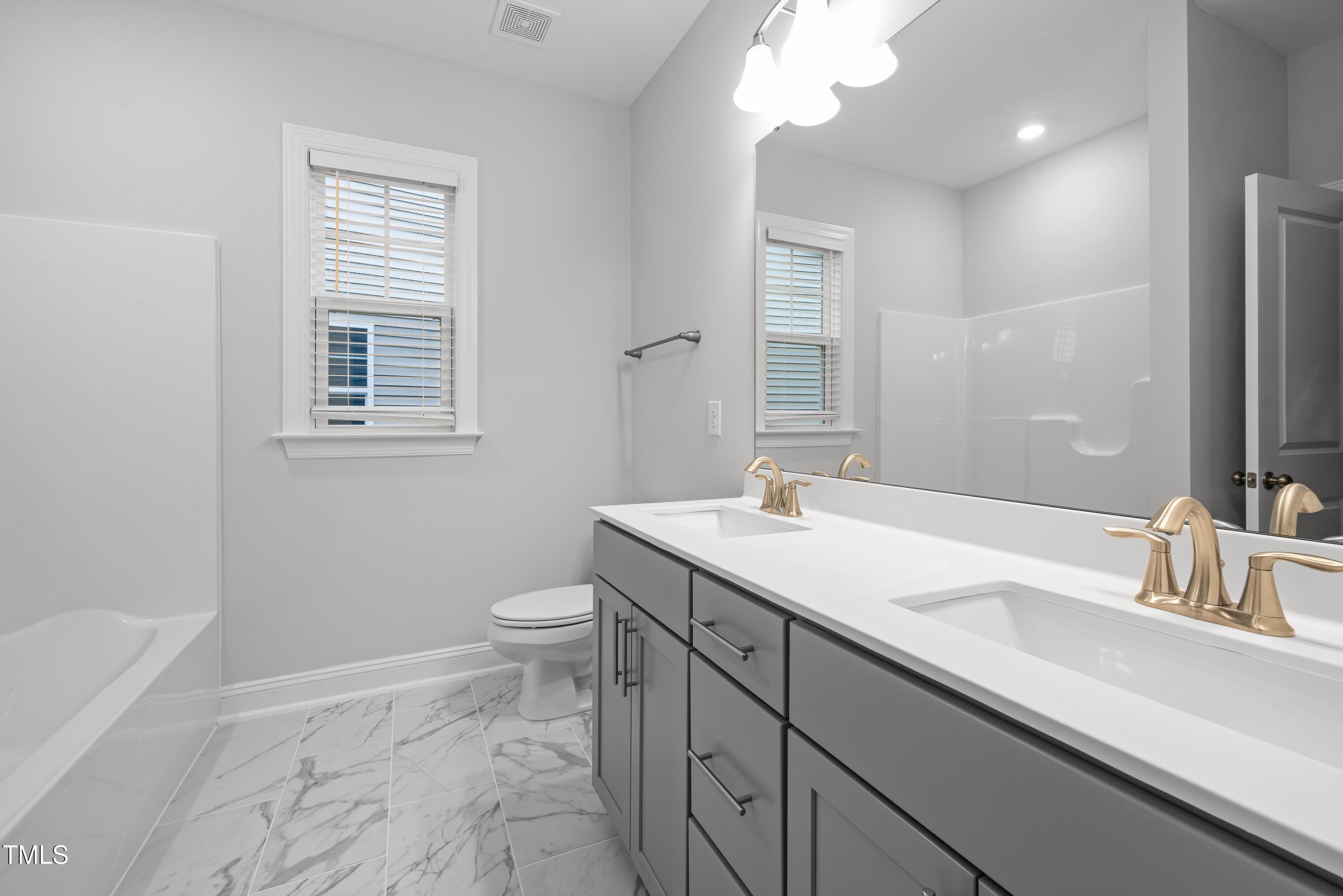 2005 Mavin Place Durham, NC 27703 - Photo 17 of 26 a bathroom with a sink a toilet and a large mirror