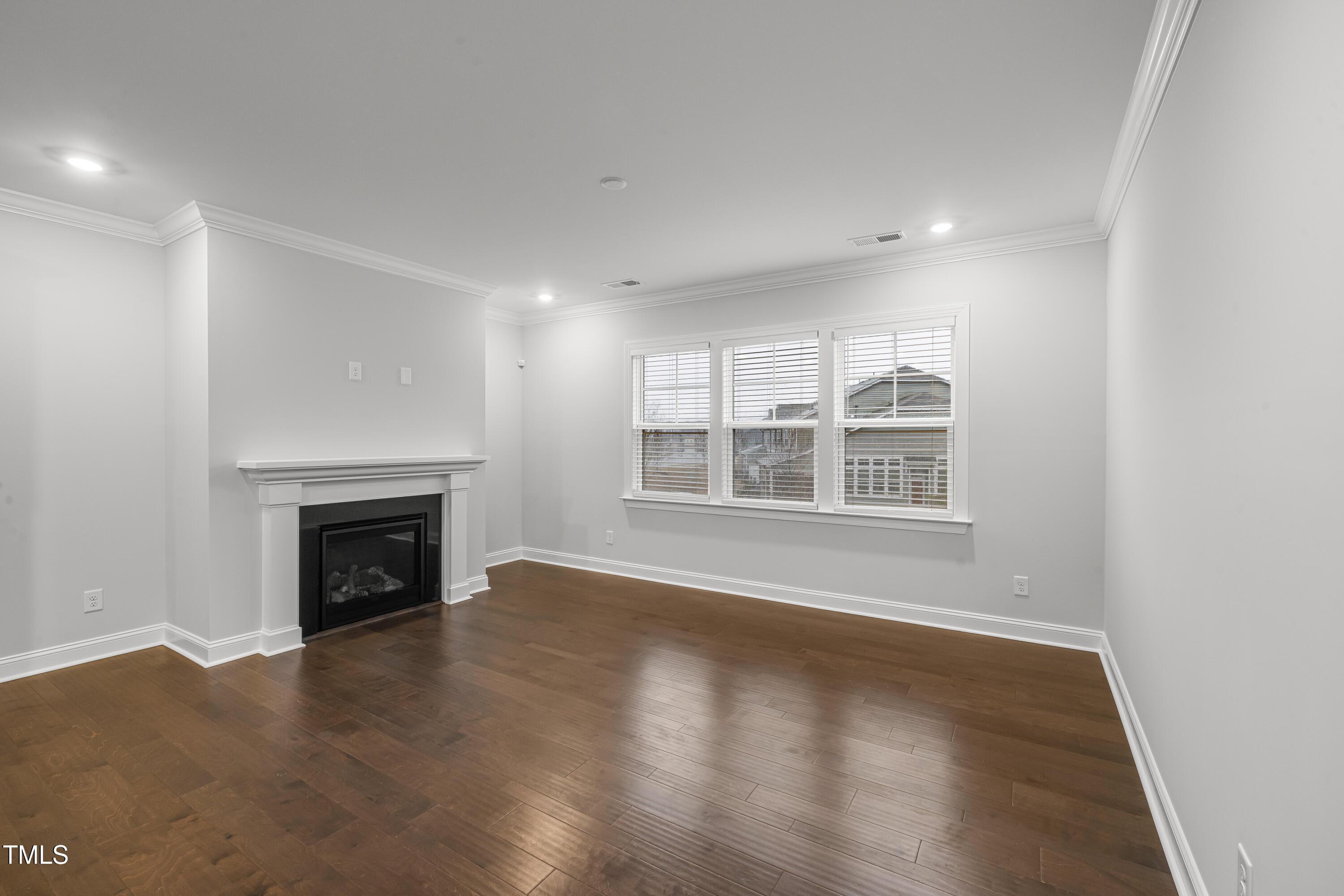 2005 Mavin Place Durham, NC 27703 - Photo 5 of 26 a view of an empty room with wooden floor fireplace and a window
