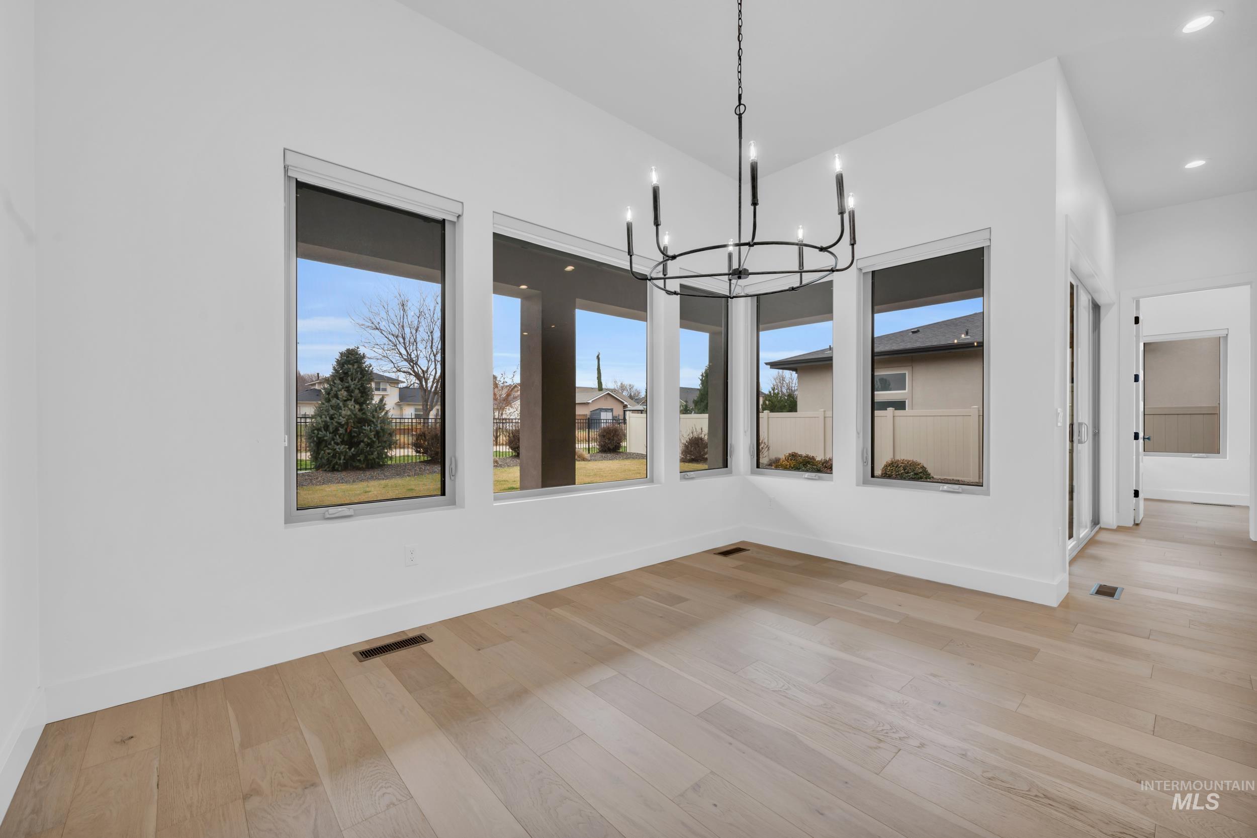4447 East Copper Point Drive Meridian, ID 83642 - Photo 18 of 42 Unfurnished dining area featuring a chandelier, light wood finished floors, and recessed lighting