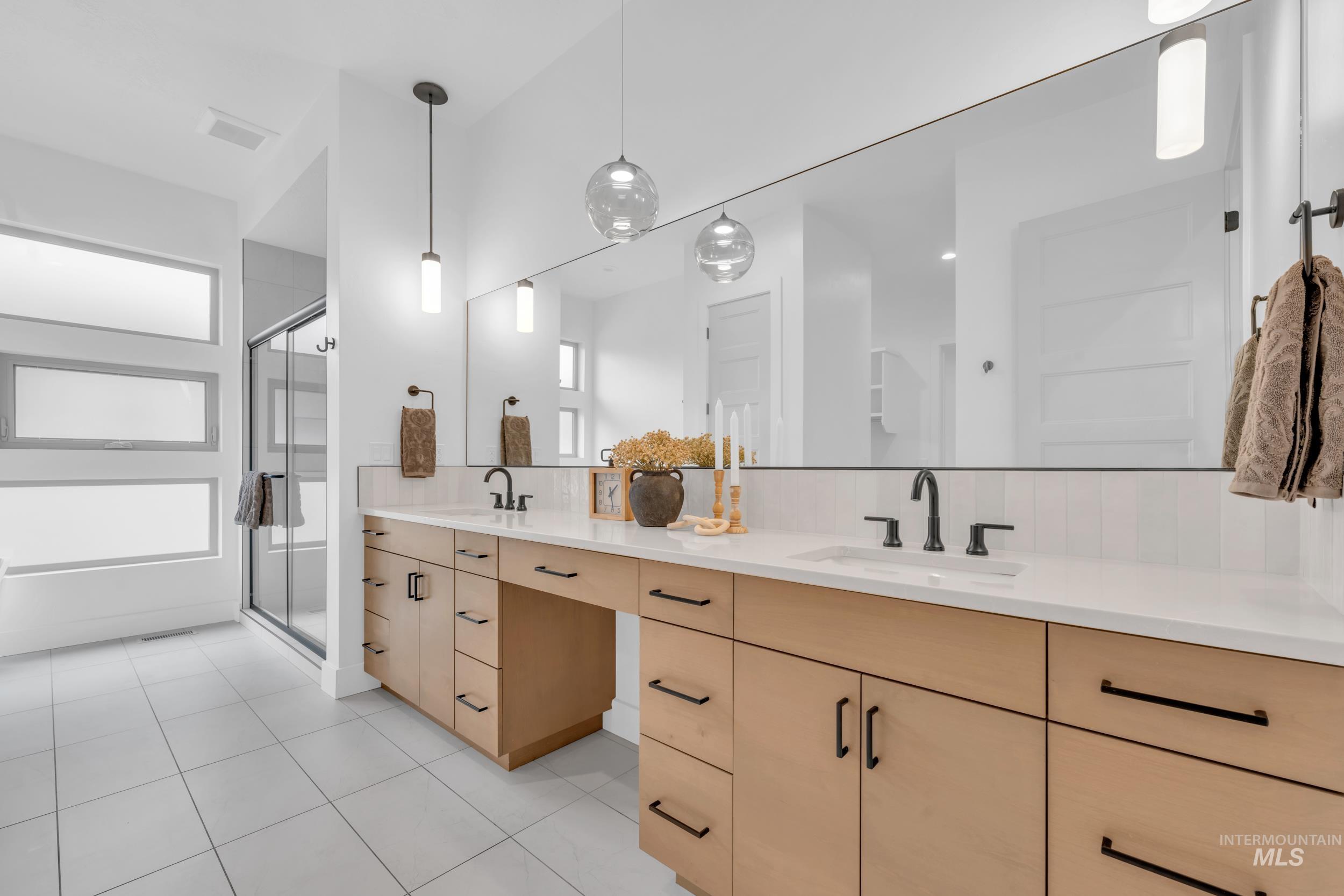 4447 East Copper Point Drive Meridian, ID 83642 - Photo 22 of 42 Bathroom with double vanity, tasteful backsplash, a stall shower, and light tile patterned floors