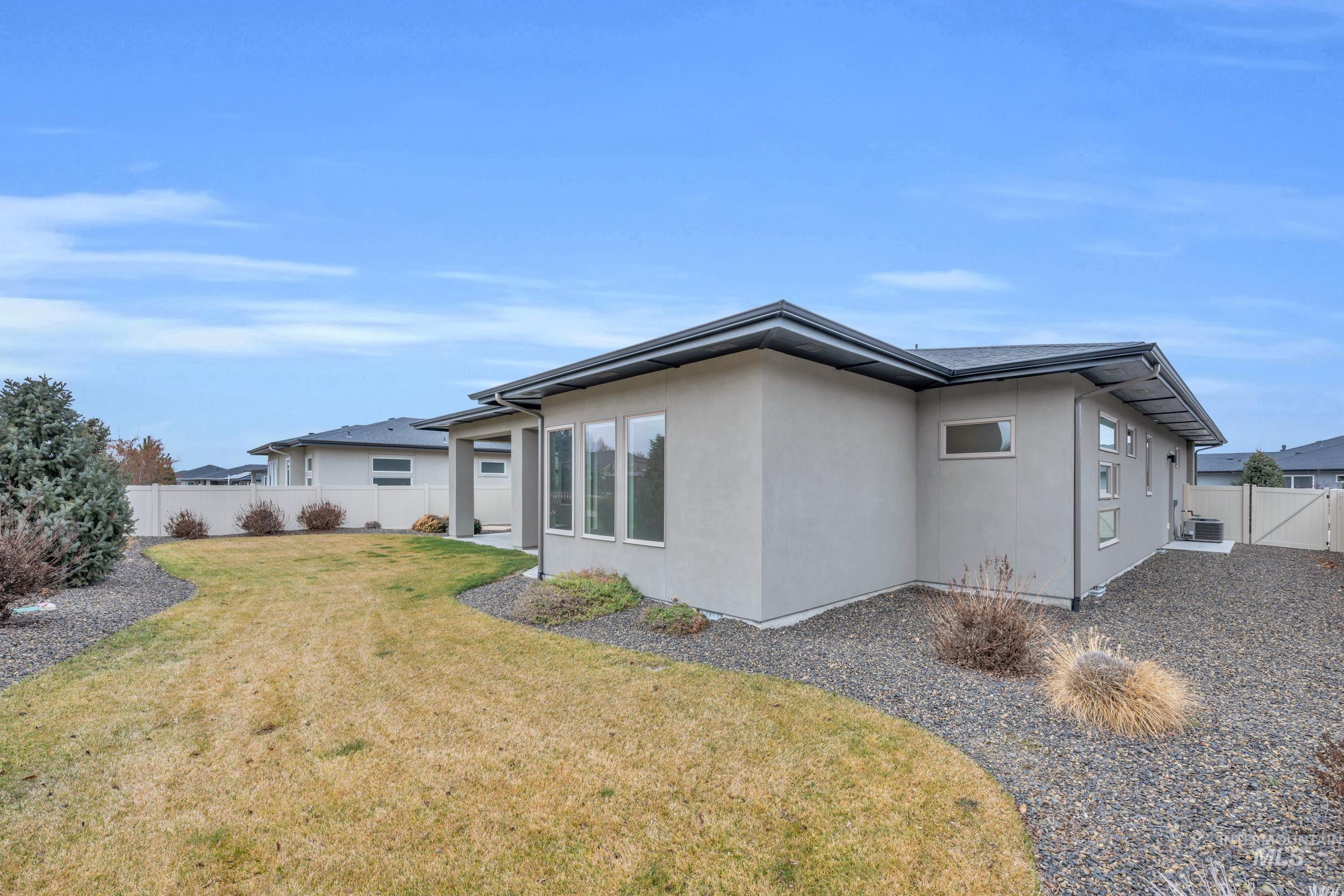 4447 East Copper Point Drive Meridian, ID 83642 - Photo 36 of 42 Rear view of house featuring a fenced backyard, stucco siding, and a gate