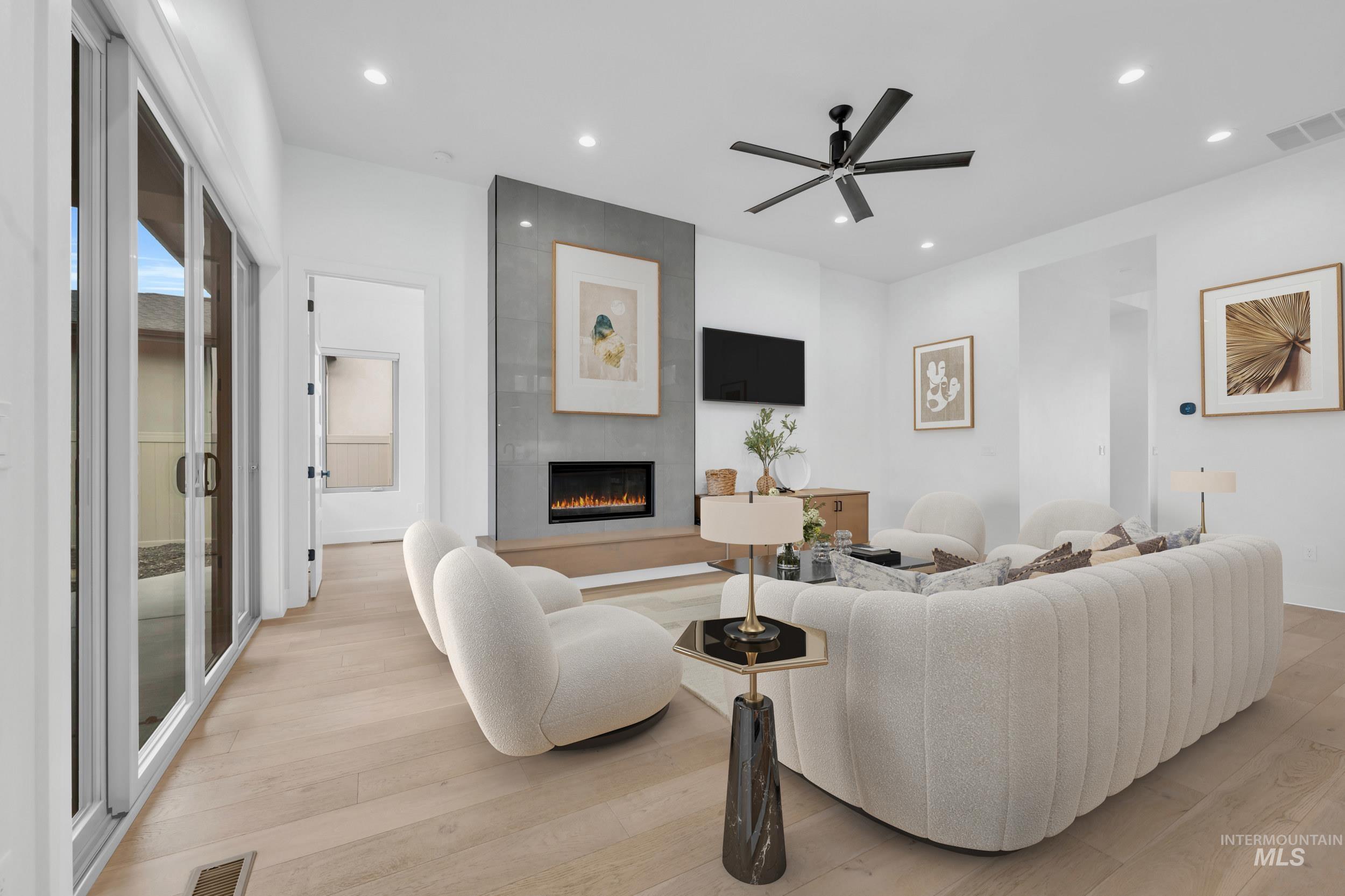 4447 East Copper Point Drive Meridian, ID 83642 - Photo 8 of 42 Living room featuring hardwood / wood-style flooring, a fireplace, recessed lighting, and a ceiling fan