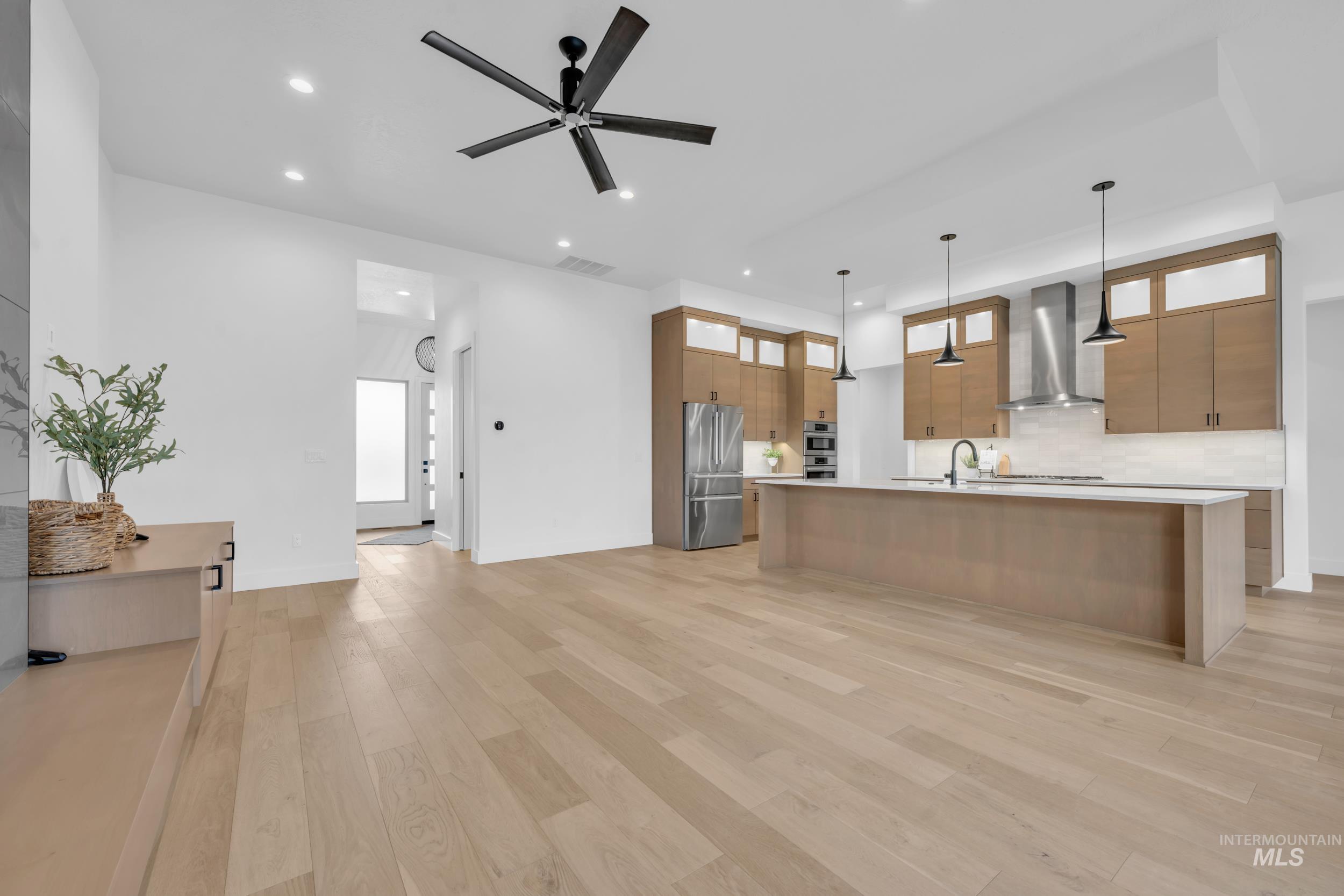 4447 East Copper Point Drive Meridian, ID 83642 - Photo 42 of 42 Kitchen featuring decorative light fixtures, a center island with sink, open floor plan, high end fridge, and modern cabinets