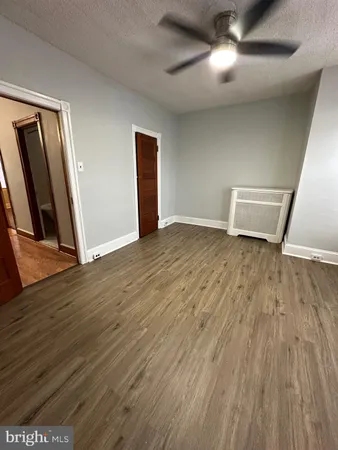 a view of an empty room with wooden floor