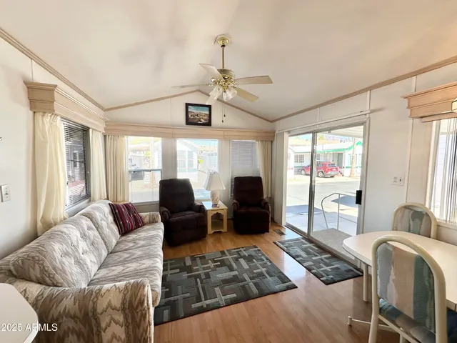a living room with furniture ceiling fan and a window