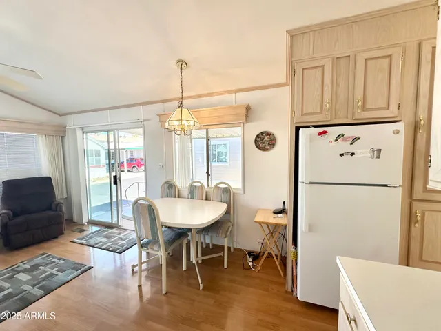 a dining room with furniture a chandelier and wooden floor