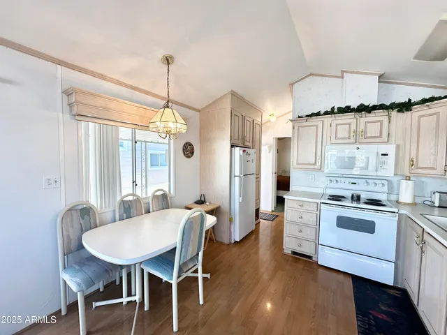 a living room with stainless steel appliances furniture and a kitchen view