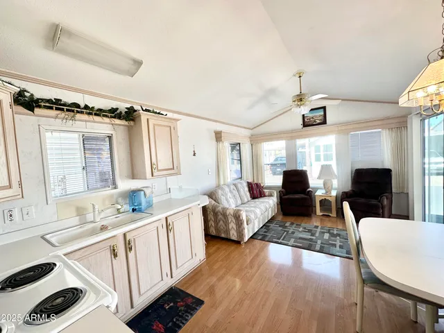 a kitchen with cabinets wooden floor and stainless steel appliances