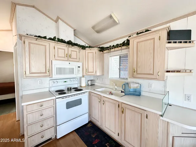 a kitchen with a sink cabinets appliances and a window