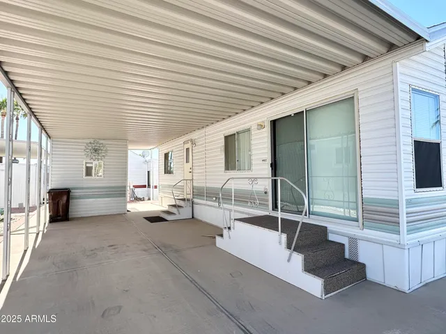 a view of a patio with couches and chairs next to window with wooden floor