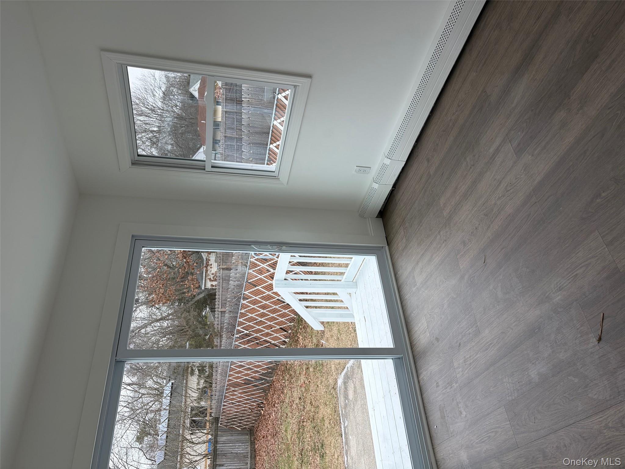182 Lexington Road Shirley, NY 11967 - Photo 12 of 16 a view of an empty room with wooden floor and a window