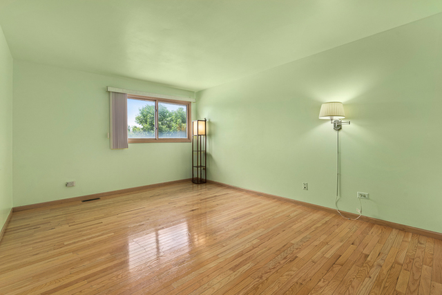 2174 Cimarron Way Addison, IL 60101 - Photo 16 of 19 an empty room with wooden floor and windows