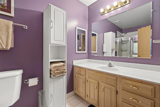 2174 Cimarron Way Addison, IL 60101 - Photo 17 of 19 a bathroom with a sink a toilet a mirror and vanity