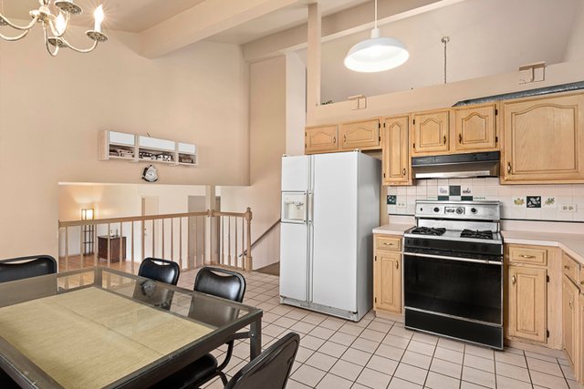 2174 Cimarron Way Addison, IL 60101 - Photo 10 of 19 a kitchen with stainless steel appliances granite countertop a stove a refrigerator a dining table and chairs