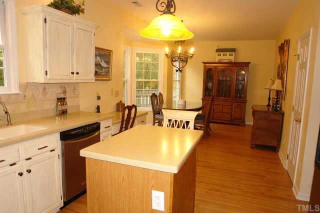 5300 Blakeley Lane Raleigh, NC 27613 - Photo 6 of 12 a kitchen with sink a refrigerator and chairs
