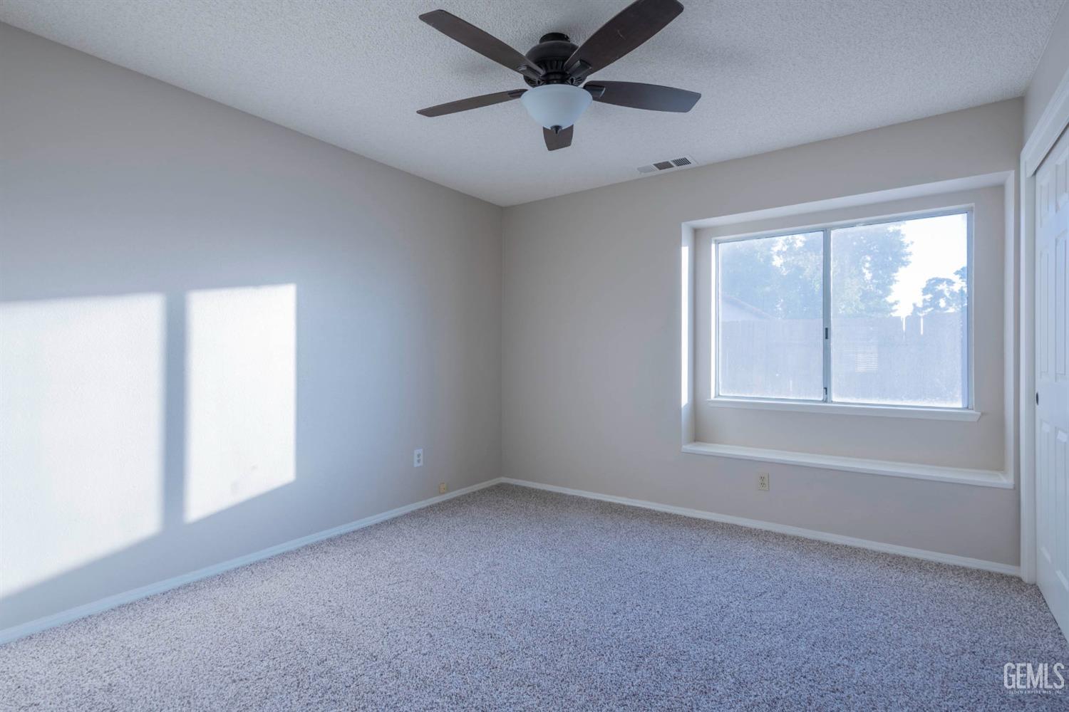 Undisclosed Address Bakersfield, CA 93314 - Photo 15 of 31 an empty room with a window and a fan
