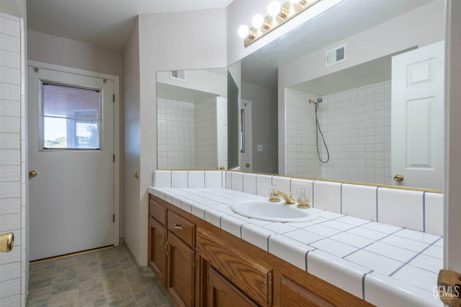 Undisclosed Address Bakersfield, CA 93314 - Photo 19 of 31 a bathroom with a granite countertop sink and a mirror