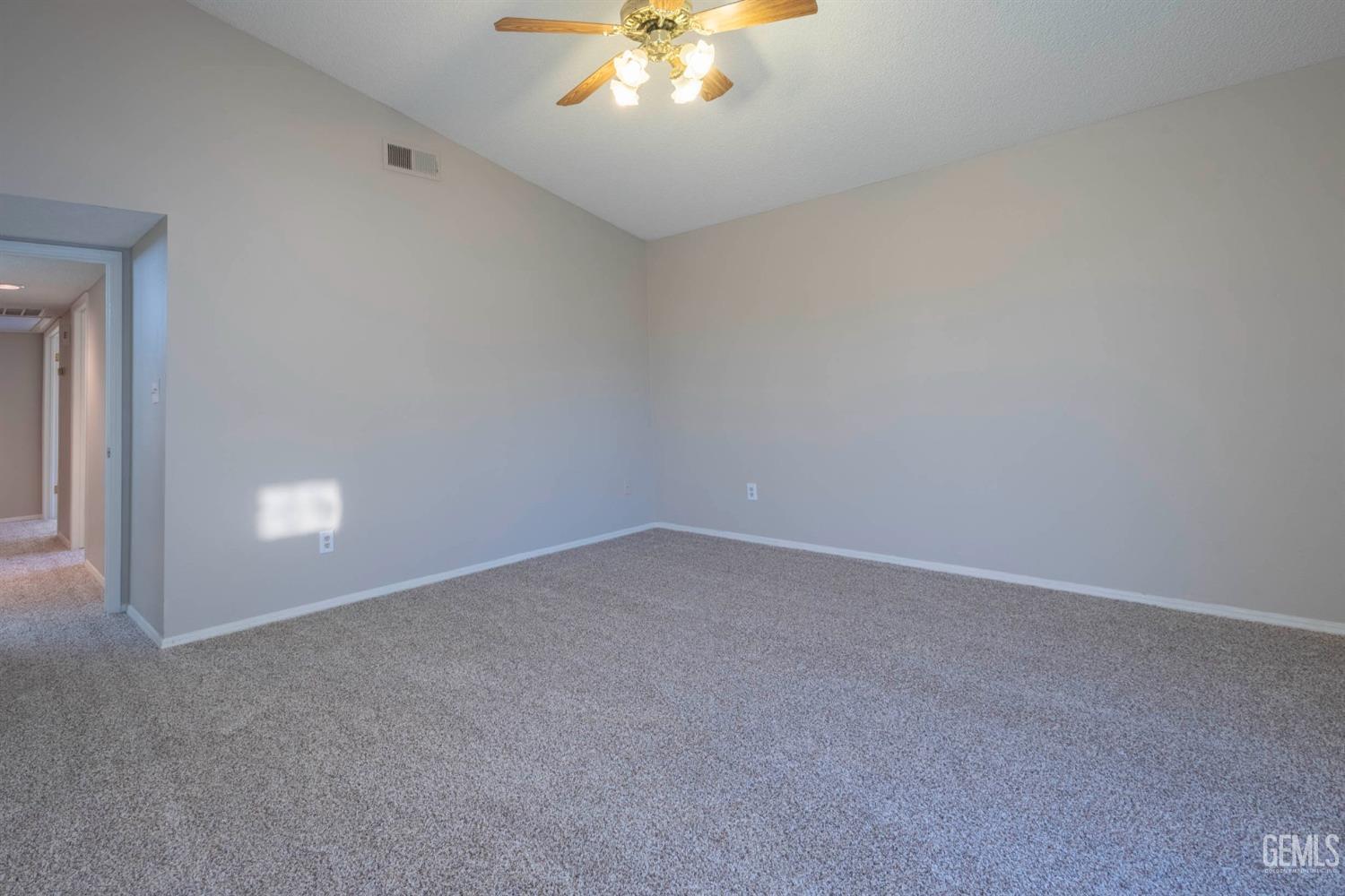 Undisclosed Address Bakersfield, CA 93314 - Photo 21 of 31 an empty room with a chandelier fan and windows