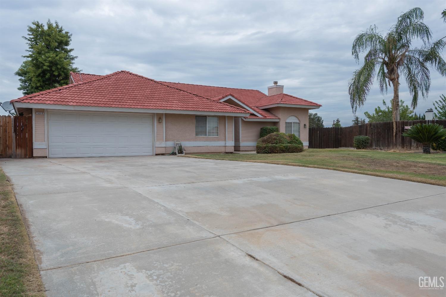 Undisclosed Address Bakersfield, CA 93314 - Photo 3 of 31 a front view of a house with a yard and palm trees