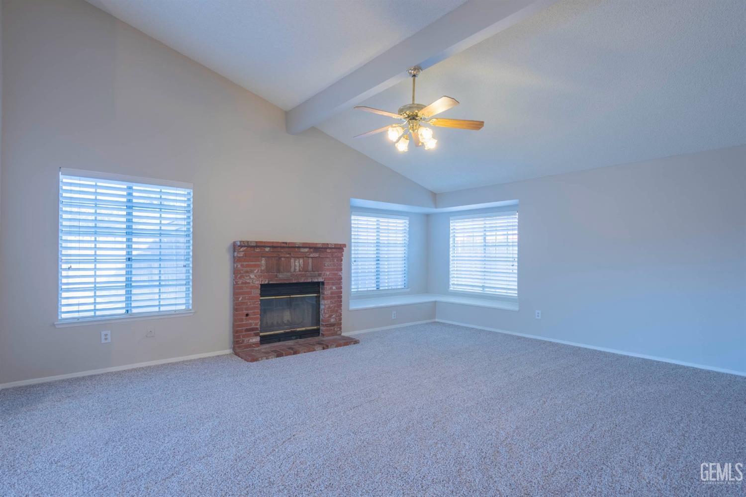 Undisclosed Address Bakersfield, CA 93314 - Photo 5 of 31 an empty room with windows fireplace and fan