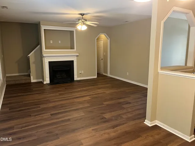 a view of a livingroom with wooden floor and a fireplace