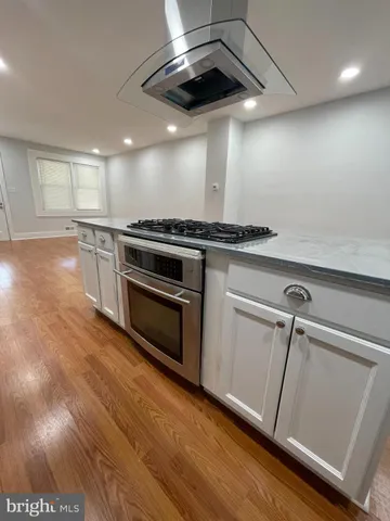 a view of a kitchen with a stove wooden floor and staircase
