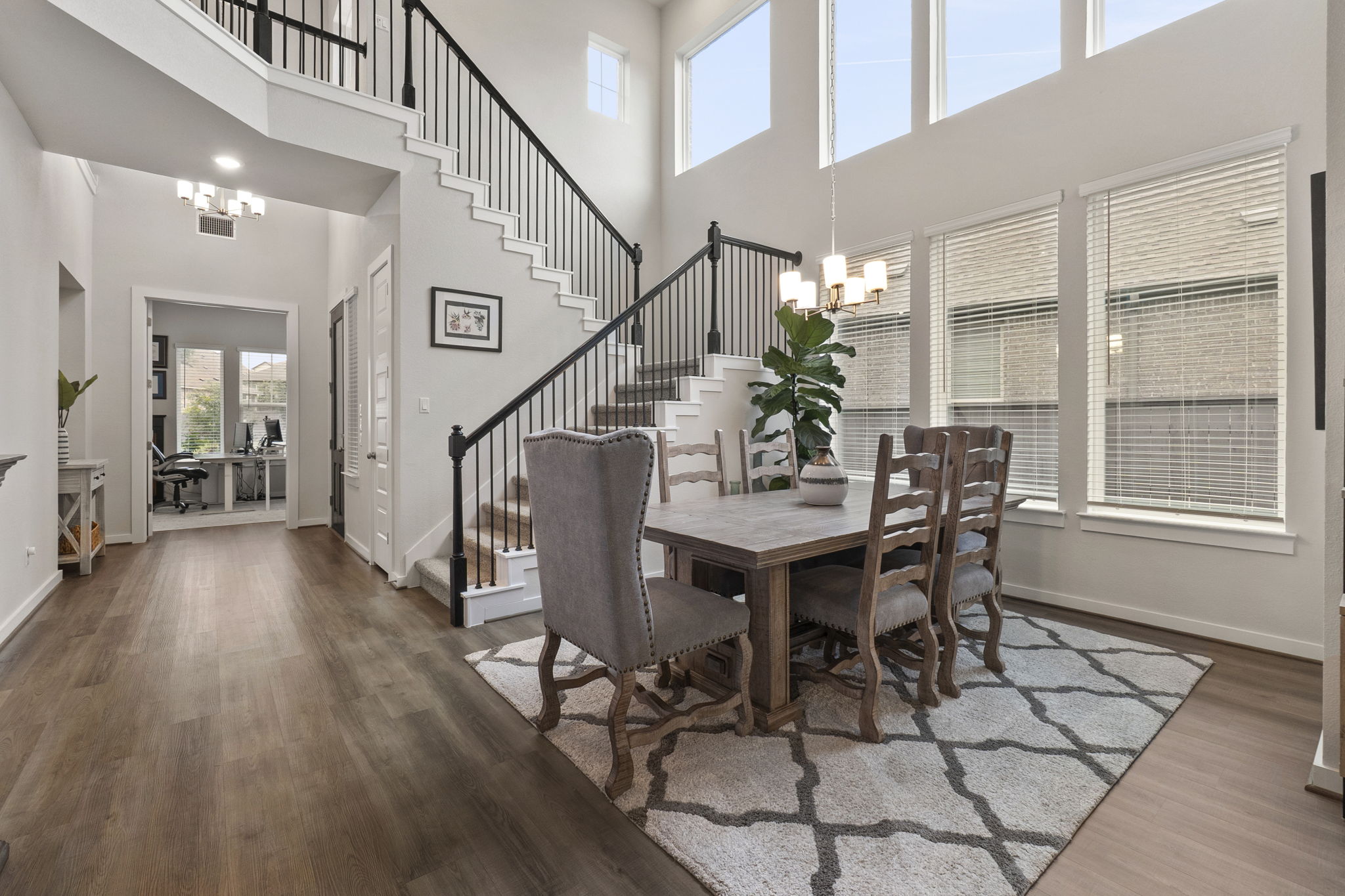 460 Constitution Way Kyle, TX 78640 - Photo 7 of 40 Two-story entryway featuring wood-finish flooring, a grand staircase with wrought iron balusters, and a contemporary chandelier