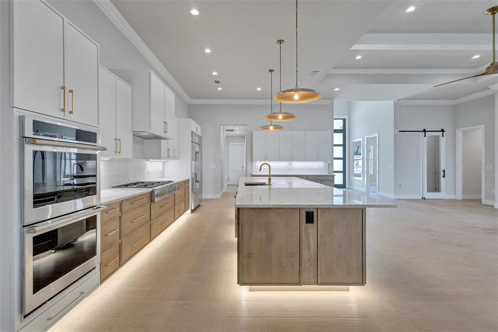 1613 148th Terrace East Parrish, FL 34219 - Photo 20 of 81 a large kitchen with stainless steel appliances kitchen island granite countertop a stove a sink and a refrigerator
