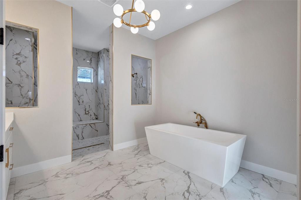 1613 148th Terrace East Parrish, FL 34219 - Photo 46 of 81 a spacious bathroom with a sink mirror and a bath tub