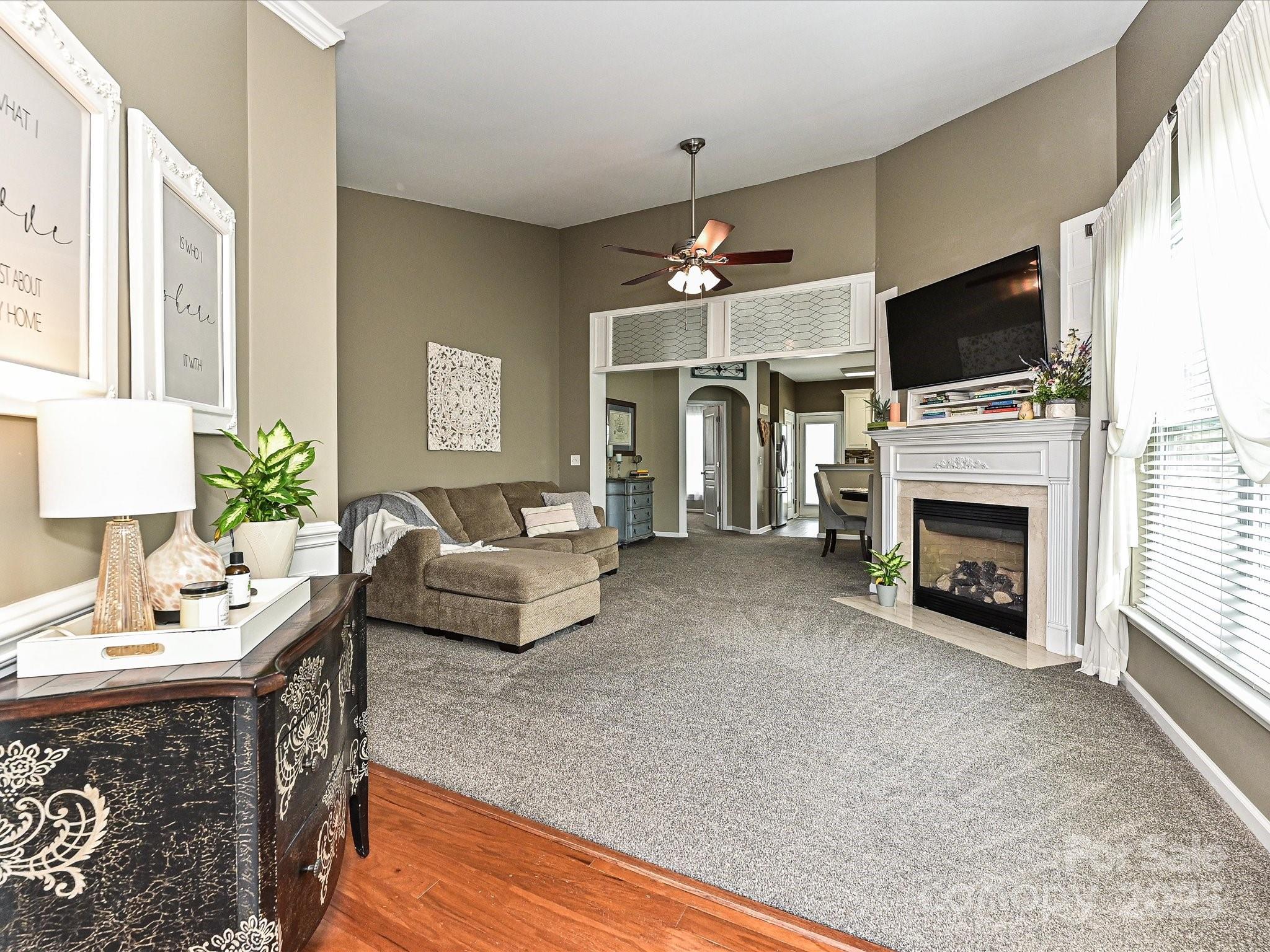 460 Silver Cypress Lane Fort Mill, SC 29708 - Photo 3 of 29 a living room with furniture a flat screen tv and a fireplace