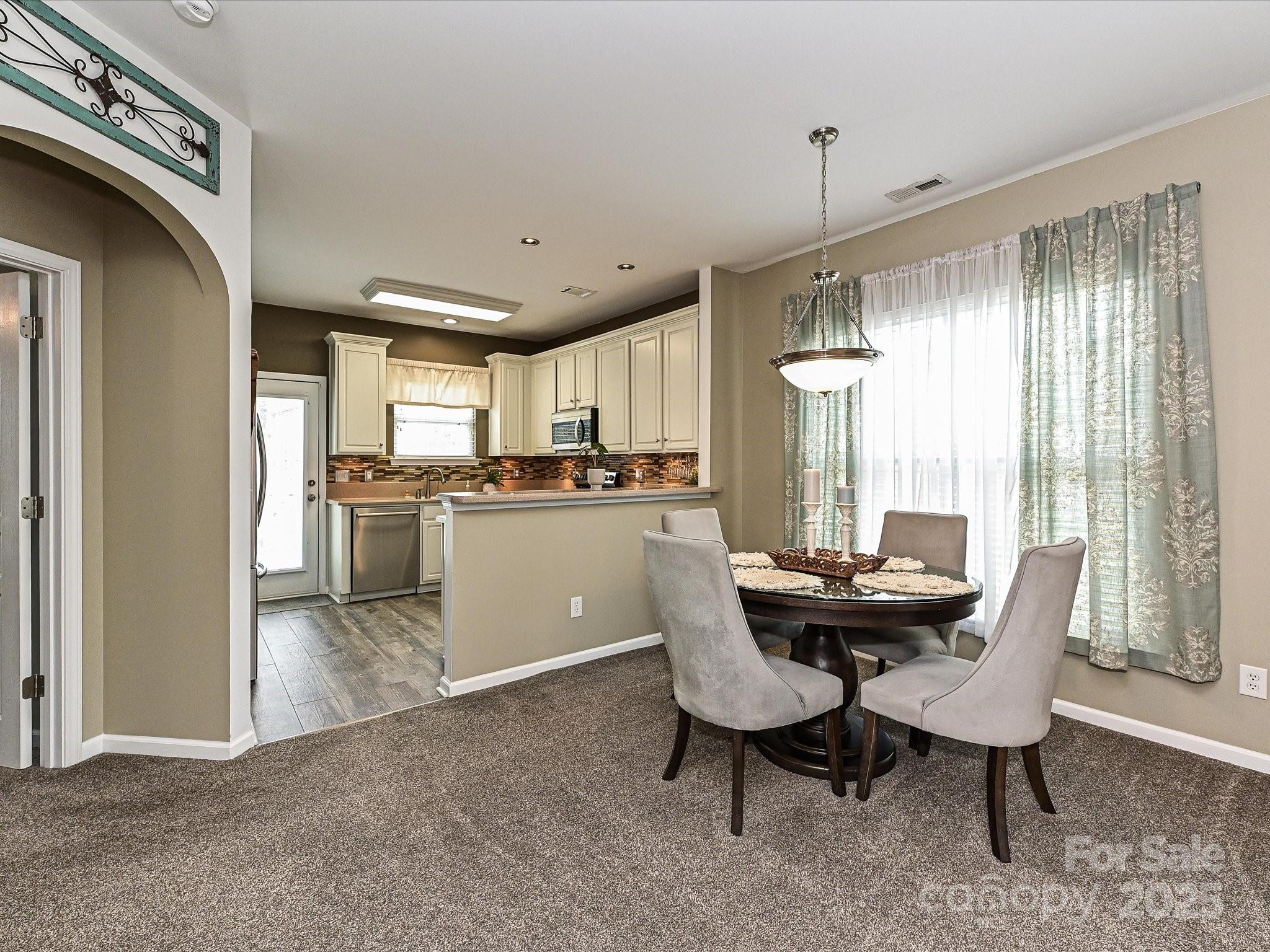 460 Silver Cypress Lane Fort Mill, SC 29708 - Photo 6 of 29 a kitchen with a table chairs refrigerator and cabinets