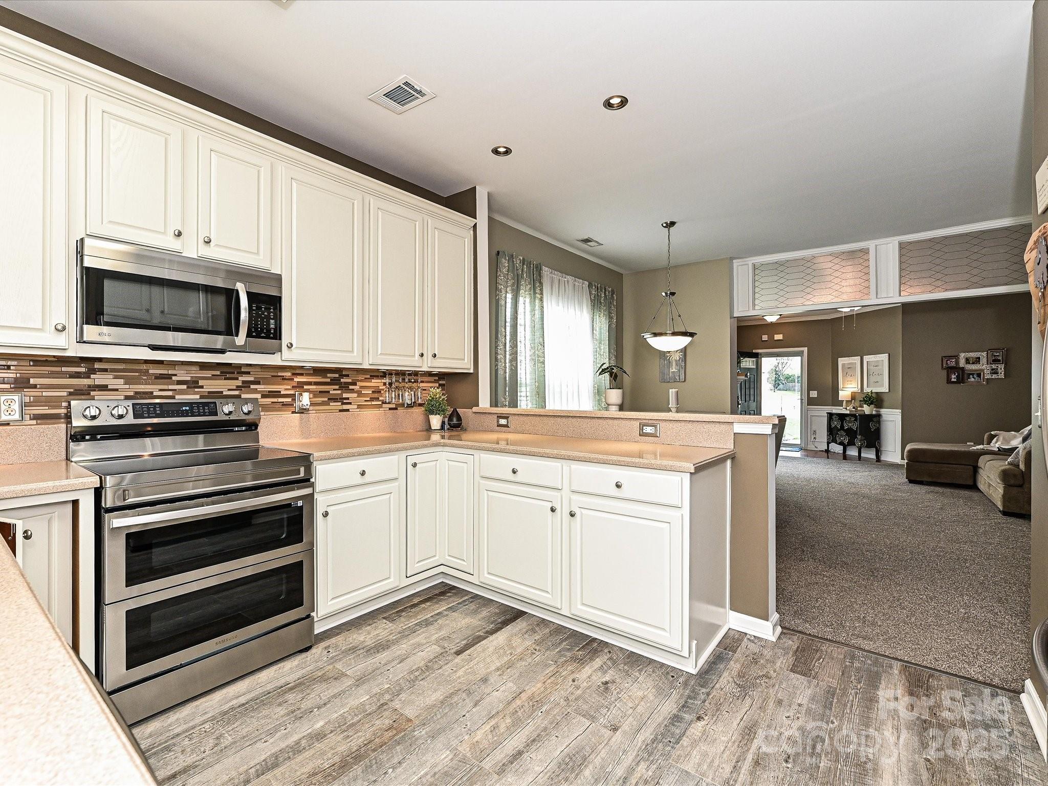 460 Silver Cypress Lane Fort Mill, SC 29708 - Photo 10 of 29 a kitchen with stainless steel appliances granite countertop a stove and cabinets