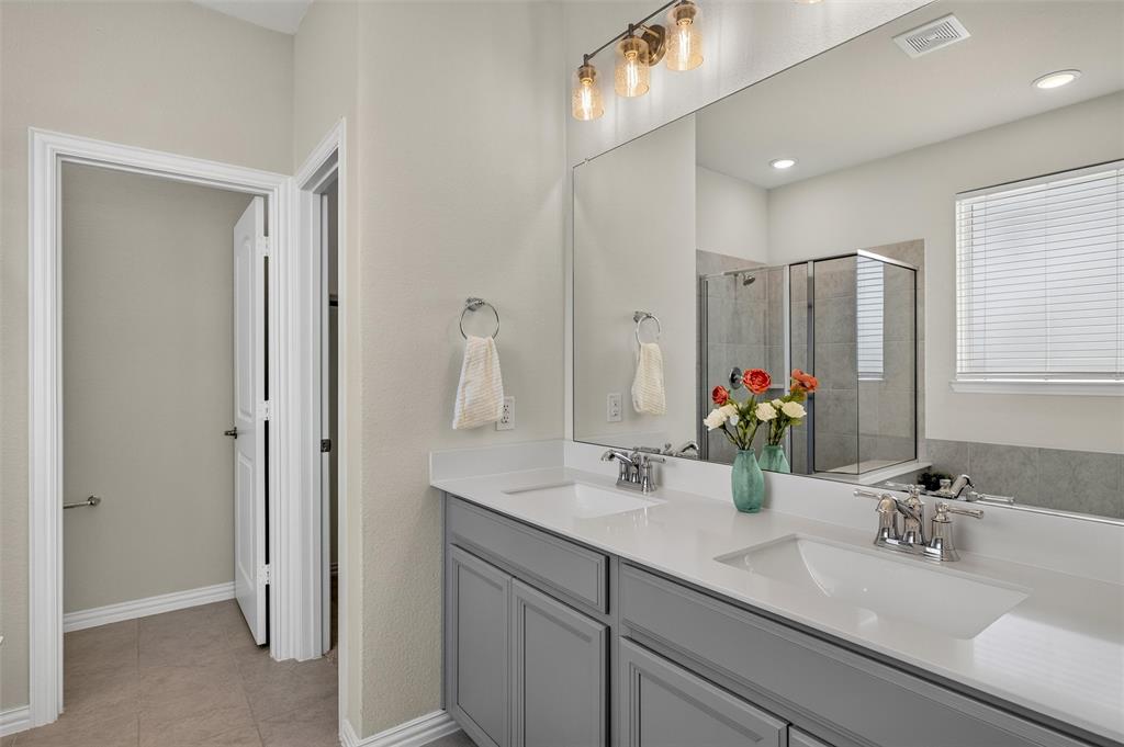8715 Royal Star Road Rowlett, TX 75089 - Photo 8 of 39 Dual vanity with undermount sinks, quartz countertops, gray cabinetry, and brushed nickel fixtures