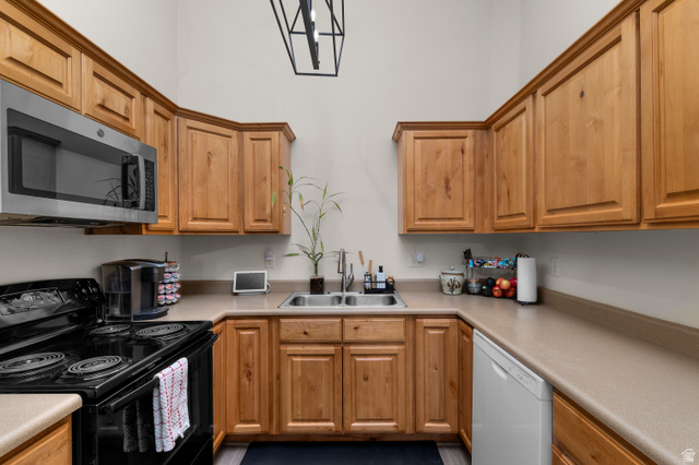 25 West Ridge Road, Unit 25 Saratoga Springs, UT 84045 - Photo 6 of 22 Kitchen featuring natural wood-finish cabinetry, light-toned countertops, and a double basin sink with a chrome faucet