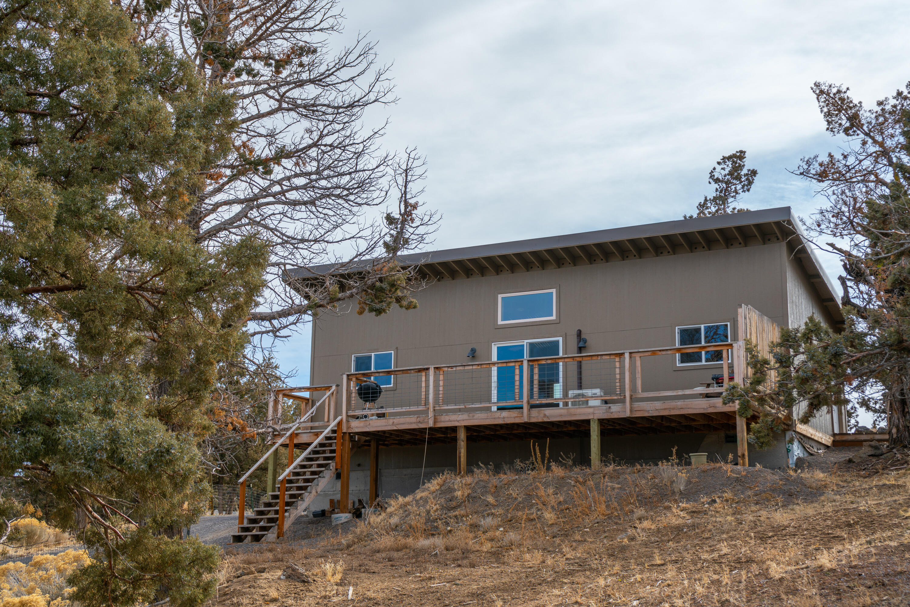 61822 Ten Barr Ranch Road Bend, OR 97701 - Photo 28 of 50 a view of house with roof and wooden fence