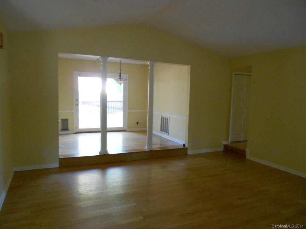 4135 Randolph Road, Unit 4 Charlotte, NC 28211 - Photo 4 of 22 an empty room with wooden floor and windows with curtains
