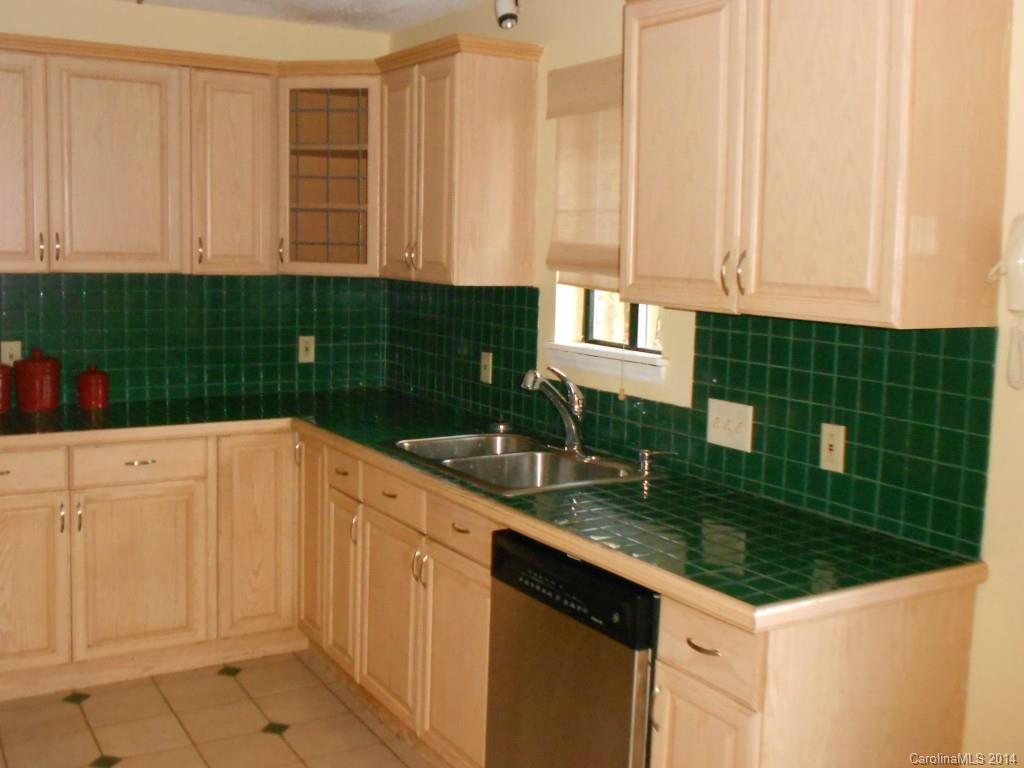 4135 Randolph Road, Unit 4 Charlotte, NC 28211 - Photo 8 of 22 a kitchen with kitchen island granite countertop white cabinets and white appliances