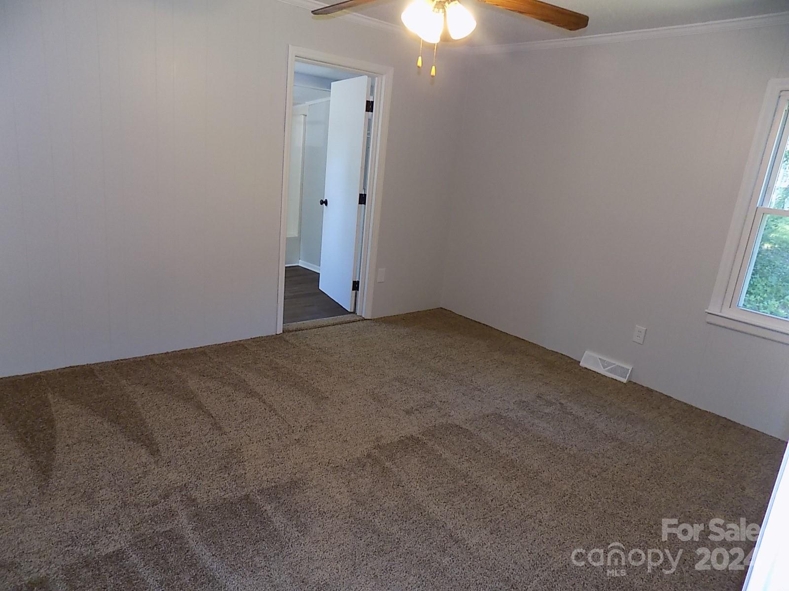 2435 Davis Park Road Gastonia, NC 28052 - Photo 8 of 10 an empty room with a window and chandelier fan