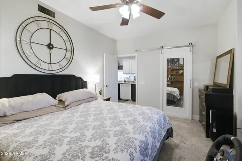a bedroom with a bed dresser and a flat tv screen