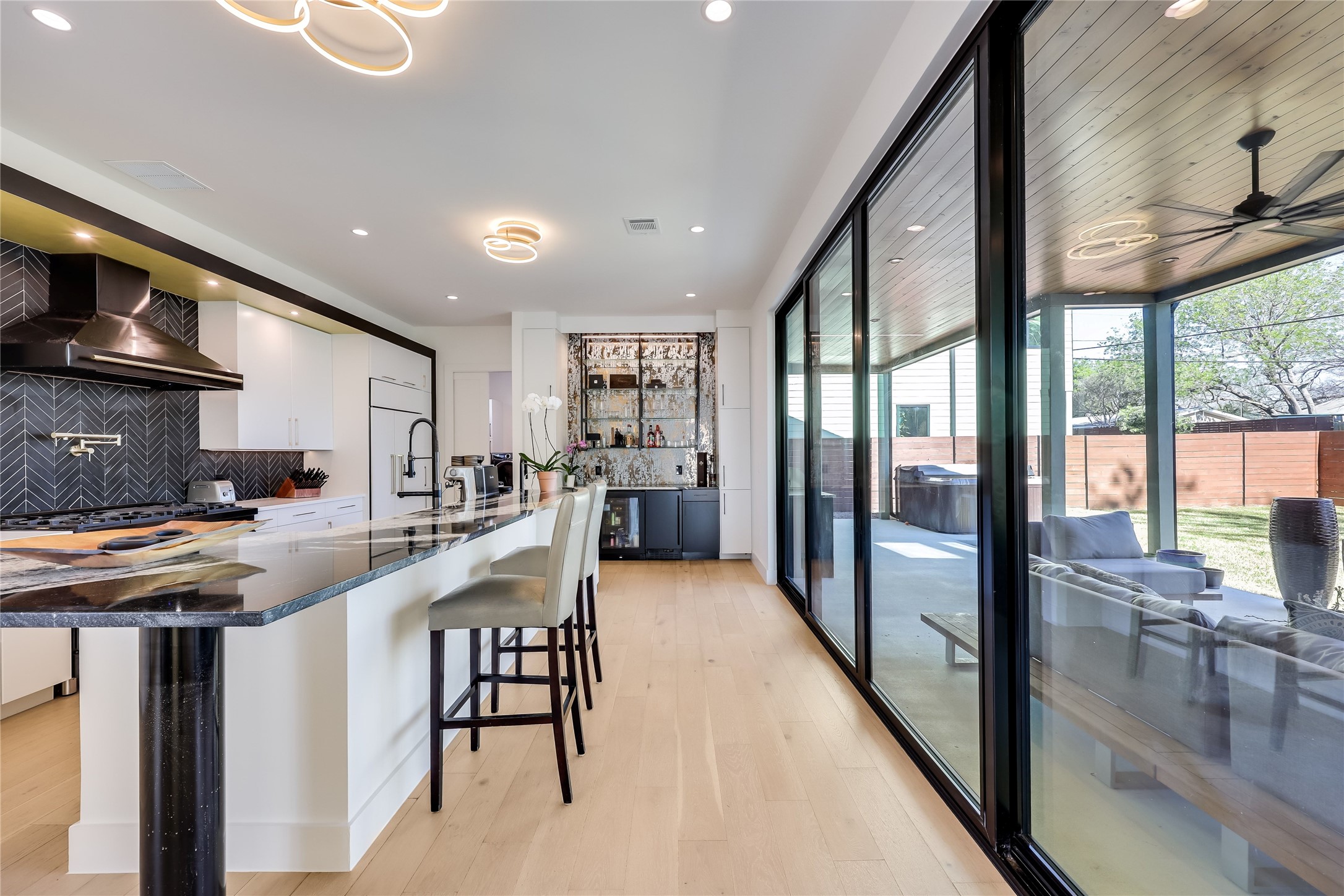 a kitchen with stainless steel appliances granite countertop a stove a refrigerator a sink and a dining table with wooden floor