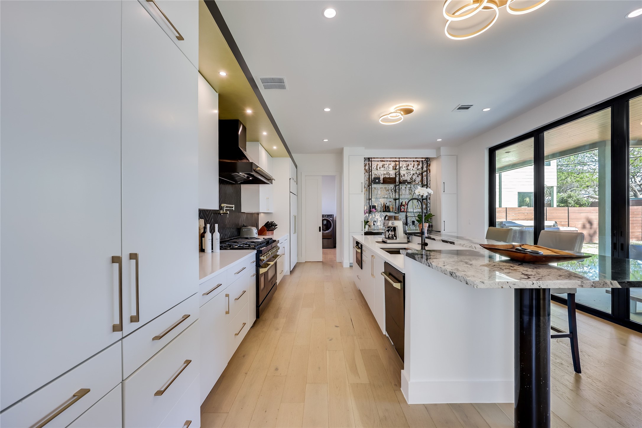 4600 Gillis Street Austin, TX 78745 - Photo 19 of 40 a large kitchen with kitchen island a large window a sink and stainless steel appliances