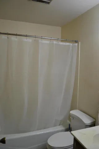 a white toilet sitting next to a shower
