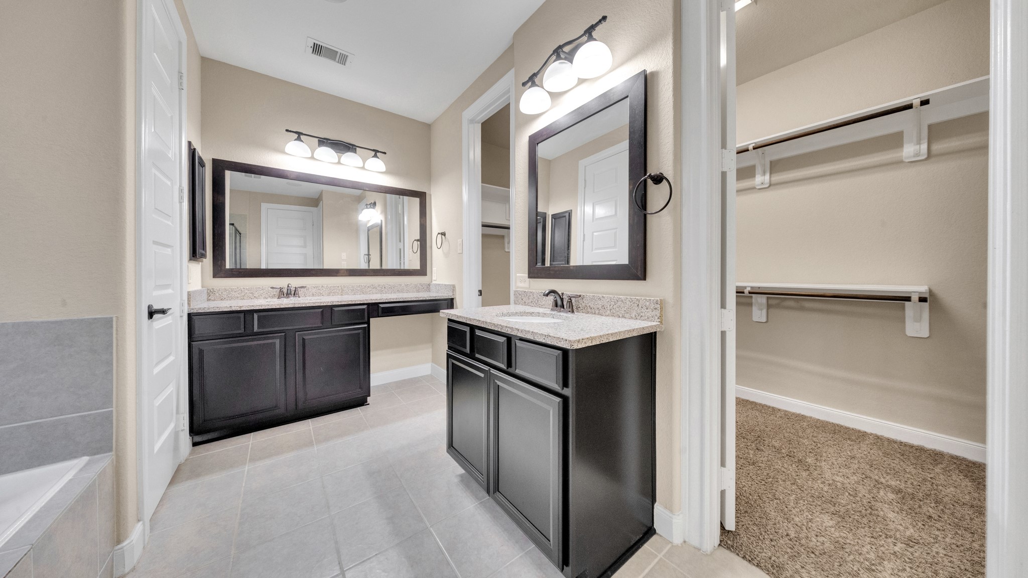 18118 Berry Garden Lane Spring, TX 77379 - Photo 21 of 45 Dual granite vanities with framed mirrors and a dedicated makeup area.