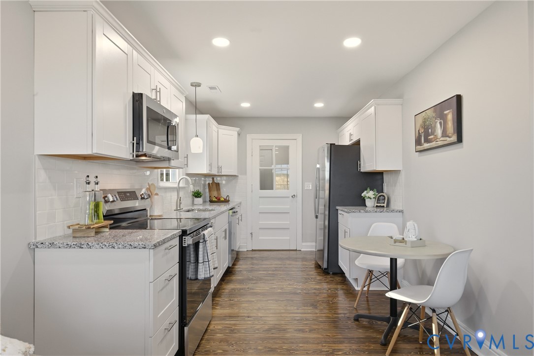 6280 Monahan Road Henrico, VA 23231 - Photo 14 of 42 a kitchen with stainless steel appliances granite countertop a stove top oven a sink dishwasher and white cabinets with wooden floor