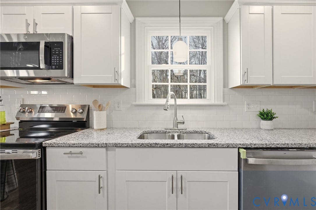6280 Monahan Road Henrico, VA 23231 - Photo 16 of 42 a kitchen with granite countertop a sink stainless steel appliances white cabinets and a window