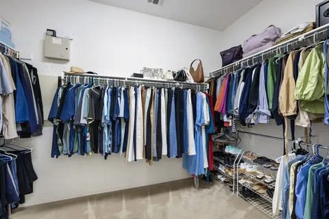 a view of walk in closet with clothes and shoes
