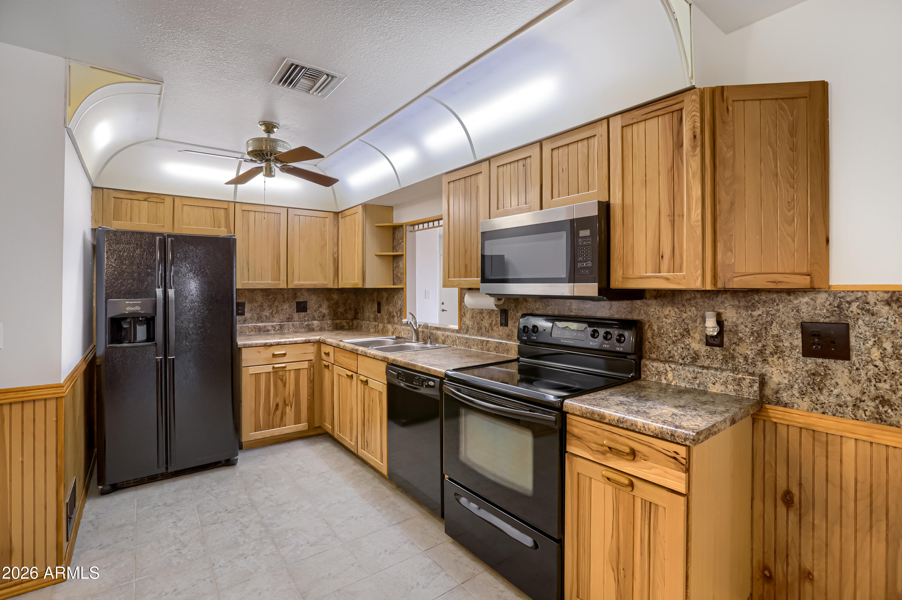 3823 West Greenway Road Phoenix, AZ 85053 - Photo 9 of 28 a kitchen with stainless steel appliances granite countertop a refrigerator stove microwave and sink