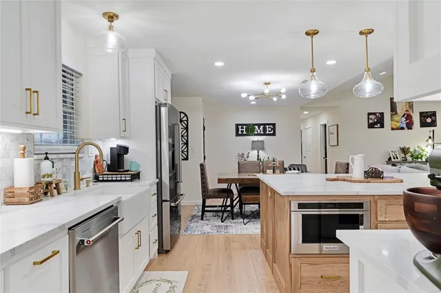 a kitchen with kitchen island a large counter top space appliances and cabinets